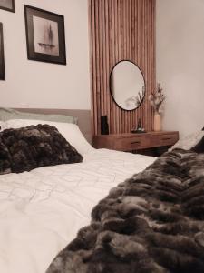 a bedroom with a white bed and a mirror at Luxury Wide View Apartment Pohorje Bellevue in Pohorje