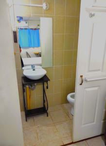 a bathroom with a sink and a mirror and a toilet at Orison Hostels Managua in Managua