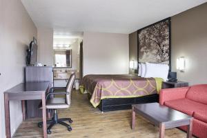 GarysburgにあるSuper 8 by Wyndham Garysburg/Roanoke Rapidsのベッドとソファ付きの小さなホテルルーム