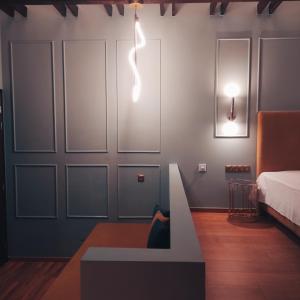 a room with a bed and a light on the wall at L Suites The Writer's House in Gythio