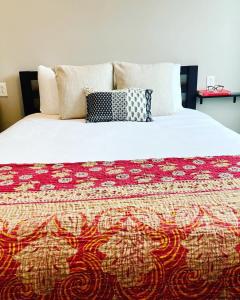 Una cama con una manta colorida y almohadas. en Pilot Four Room For Two With Pool, en Pacific