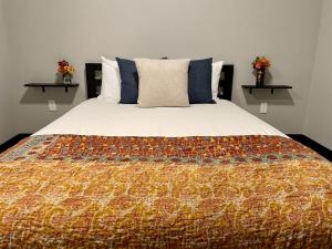 a bedroom with a large bed with a colorful blanket at St Louis Staycation Destination in Pacific