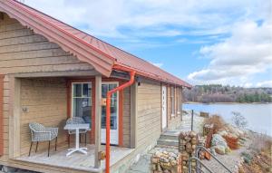 Cozy Home In Uddevalla With House Sea View في Sundsandvik: كابينة فيها سطح مع طاولة وكرسي