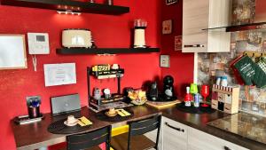a kitchen with a counter with a red wall at creedhouse in the historic center in Casamassima