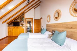 two beds in a room with white and blue pillows at Casa Lali Habitación baño compartido in Las Lagunas