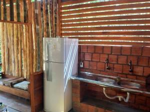 a refrigerator in a kitchen next to a sink at Cabana tucuxi in Novo Airão