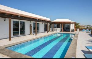 a swimming pool in front of a house at Villa Pipa Puerto Calero in Puerto Calero