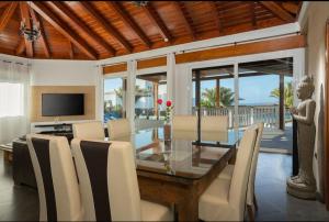 a dining room with a glass table and chairs at Villa Pipa Puerto Calero in Puerto Calero