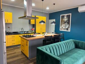 uma cozinha com armários amarelos e um sofá verde em Casa en pichilemu em Pichilemu