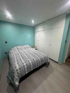 um quarto com uma cama e armários brancos em Casa en pichilemu em Pichilemu