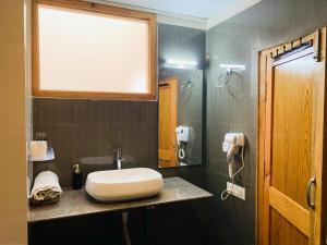 a bathroom with a white sink and a window at The Bulevar - Whispering Willows in Sissu