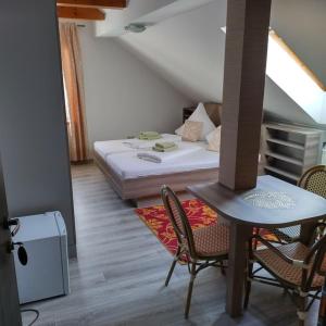 a room with a bed and a table and chairs at Pension Goldenes Vogtland in Adorf