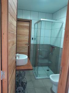 a bathroom with a sink and a glass shower at Cabaña Aike de Sierra de los Padres in Sierra de los Padres