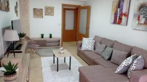比拉加爾西亞德亞羅薩的住宿－Casa Preguntoiro，客厅配有沙发和桌子