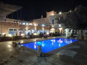 a swimming pool in front of a building at night at Riad Malak in Ouirgane