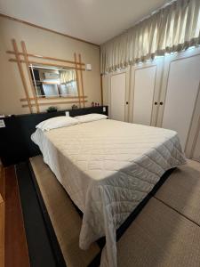 a bedroom with a large bed with a white comforter at Hotel Estoril Garden & Restaurante in Registro +13 photos