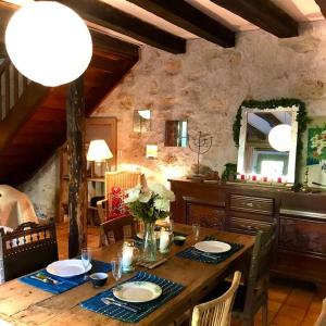 a dining room with a table with chairs and a mirror at Maison des Séquoias - Parc 1 hectare- in Veyrac