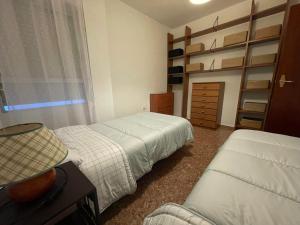 een slaapkamer met 2 bedden en een dressoir en planken bij Benidorm in Villajoyosa