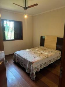 ein Schlafzimmer mit einem Bett in einem Zimmer mit einem Fenster in der Unterkunft Chácara Alvorada - Conchal in Conchal