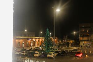 een kerstboom op een parkeerplaats voor een gebouw bij Estancia en Pontedera in Pontedera