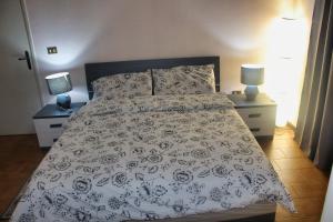 een bed in een slaapkamer met 2 nachtkastjes en 2 lampen bij Estancia en Pontedera in Pontedera