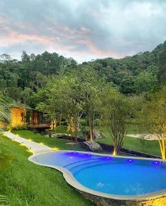 a swimming pool in the middle of a yard at Villa Tanah in São Roque