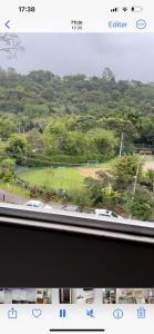 a view from a window of a park with a field at Apartamento Centro ao lado do Country Club in Nova Friburgo