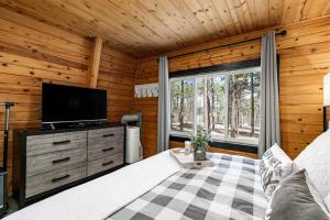 a room with a bed and a television in a cabin at Grand Canyon Cabin! One hour and 10 minutes to the South Entrance! in Williams