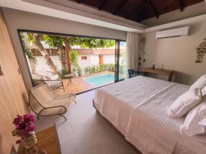 a bedroom with a bed and a view of a pool at Poozendin Hotel de Charme in Canoa Quebrada +66 photos