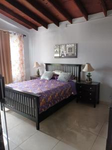 a bedroom with a bed with a purple comforter at Apartamentos Rosarito.!! Con Vista al Mar ! in Rosarito