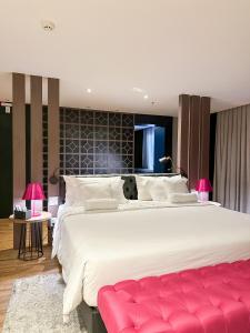 a large bedroom with a large bed with a red bench at QS Marista Hotel in Goiânia