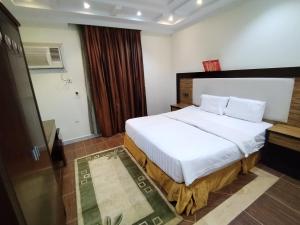 شقق الاحلام بحراء للايجار الشهري والسنوي في جدة: غرفة نوم مع سرير أبيض كبير في غرفة