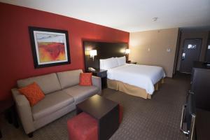 een hotelkamer met een bed en een bank bij Holiday Inn Express Hotel & Suites Chatham South, an IHG Hotel in Chatham