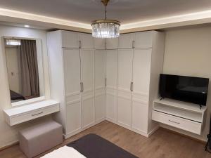 Cette chambre dispose d'armoires blanches, d'une télévision et d'une télévision. dans l'établissement Refined elegant private room, au Caire