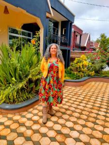 a woman is standing in front of a house at Unique Homestays B in Karatu