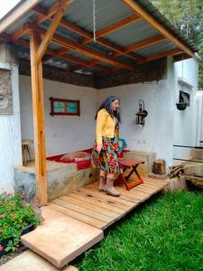 a woman standing on a wooden deck with a bed at Unique Homestays B in Karatu