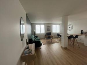 a living room with a green couch and a table at T3 Orléans charmant avec parking centre-ville in Orléans +13 photos