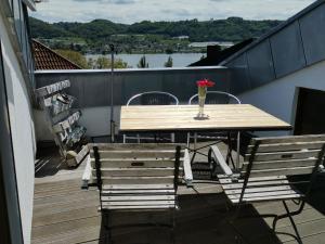 une table et des chaises sur un balcon avec un vase de fleurs dans l'établissement Sonnenblume, à Öhningen