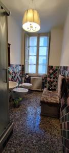 baño con 2 aseos, lavamanos y lámpara de araña en affittacamere Monte inni, en Ozieri