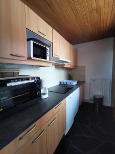 eine Küche mit einer Mikrowelle und einer Arbeitsplatte in der Unterkunft Résidence Jannu - 3 Pièces pour 8 Personnes 034 in La Plagne Tarentaise