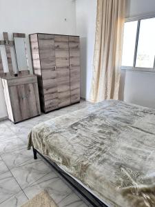 une chambre avec un grand lit et une commode dans l'établissement Diar Amina, à Midoun