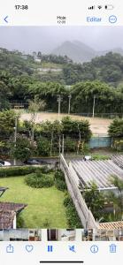 a view of a field with trees and a fence at Apartamento Centro ao lado do Country Club in Nova Friburgo