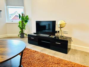 a living room with a tv and a table at Margate Spacious Apartment - 5 min walk to beach in Margate