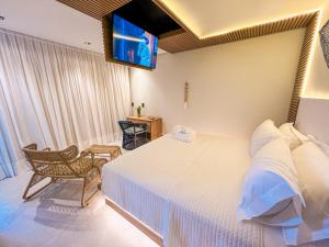 a bedroom with a bed and a tv on the wall at Poozendin Hotel de Charme in Canoa Quebrada