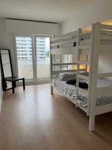 sypialnia z łóżkiem piętrowym i dużym oknem w obiekcie Bright Apartment With Sea View w Ostendzie