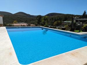 TurísにあるBuen Estar, piscina, barbacoa, jacuzzi en Valenciaの山々を背景にした青い大型スイミングプール