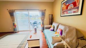 sala de estar con sofá y mesa en Lake Marie Lodge #32 en Rockaway Beach