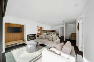 a living room with a couch and a fireplace at Residence du Parc - Luxury Apartment in Paraparaumu Beach