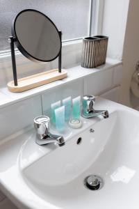 a bathroom sink with a mirror on top of it at Air Host & Stay - Newcombe House, 3 bedroom free parking in Liverpool