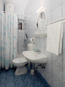 a bathroom with a sink and a toilet and a mirror at Apartments Dr. Vlasic in Podstrana